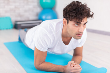 Fototapeta na wymiar motivated young man doing push ups on an exercise mat