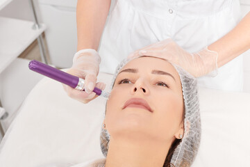 Cosmetologist makes mesotherapy injection for rejuvenation woman face, anti aging non surgical...