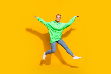 Fototapeta na wymiar Full size photo of crazy cheerful girl have good mood jumping raise arms isolated on yellow color background