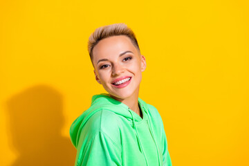 Closeup portrait of satisfied pretty lovely girl wear green hoodie smiling blonde short hair enjoy her lifestyle isolated on yellow color background