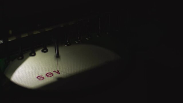 sewing machine embroiders blue inscription. High quality 4k footage