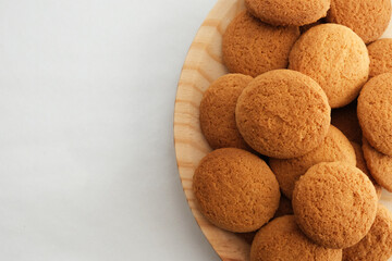 wooden plate with cookies on gray background
