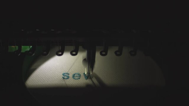 sewing machine embroiders blue inscription. High quality 4k footage