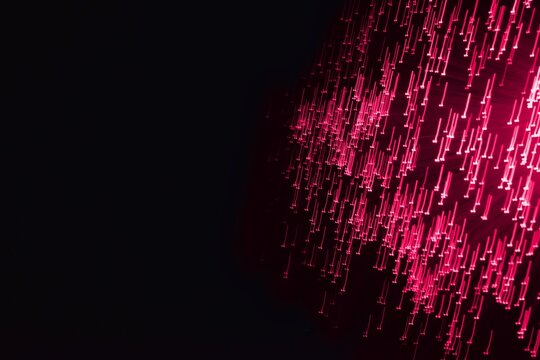 Abstract neon light in trendy color Viva Magenta on the black background. Color of the year 2023.