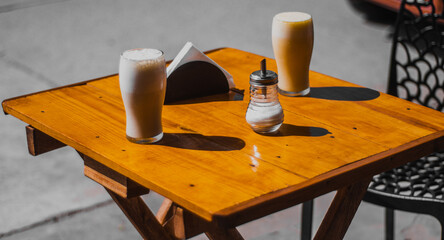 Mesa bacía en una vereda con dos basos de licuado