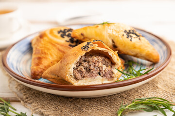 Homemade asian pastry samosa on white wooden. side view, selective focus.