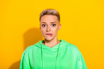 Photo of scared nervous young pretty girl biting lips staring isolated on yellow color background