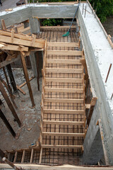 Built formwork template with metal reinforcement for pouring concrete solution of staircases, between floors of the house, immediately at the site of construction of the house