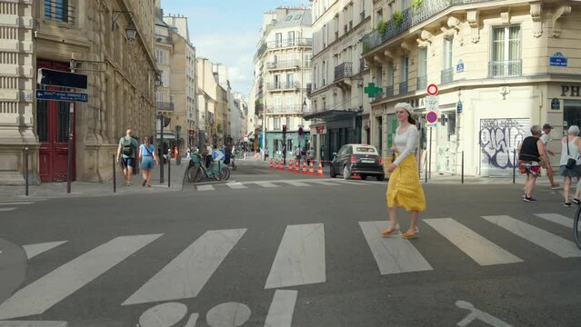 Young French woman crossing the road at a crosswalk in Paris