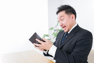財布を見て驚くビジネスマン