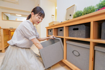 棚の片付けをする若い女性