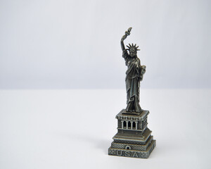 Miniature of the Statue of Liberty made of metal on a white background. © Anggi