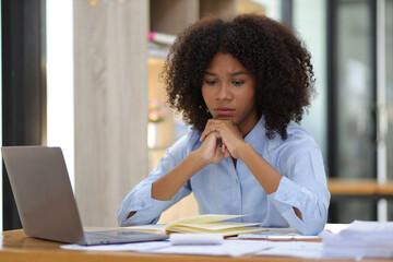 African woman in office stressed and worried about unsuccessfully working on deadlines. Stress and pressure of overwork.