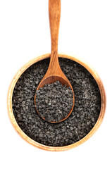 Top view of wooden bowl with spoon and black salt over white background.