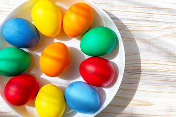 There are Easter eggs in the white plate. Flat lay