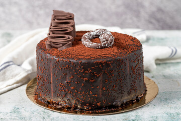 Chocolate cake on a gray background. A birthday or celebration cake filled with strawberries, bananas and chocolate. Bakery desserts. close up