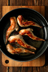 Frying pan with fried rabbit legs