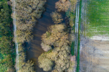 aerial view of a river in winter with the trees without leaves