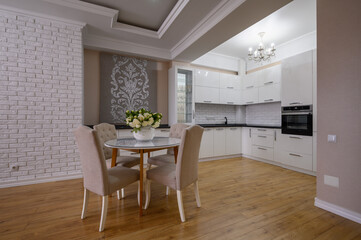 Fototapeta na wymiar Luxury white modern kitchen with rose walls in studio apartment