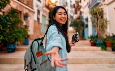 Deurstickers Asian female tourist student on city streets © Valerii Apetroaiei