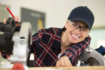 portrait of female carpenter using a circular saw