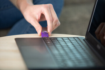 woman hand plugging a pendrive in a laptop