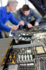 mechanic tools at garage with mechanics in the background