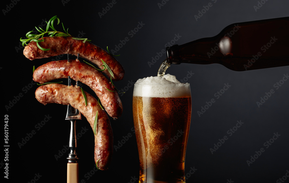 Wall mural Beer and grilled sausages with rosemary.