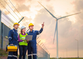 Technician engineer in uniform with standing and checking wind turbine power farm power generator...