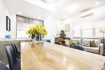 Double-height living-dining room with a wall covered with pine wood and matching vintage stoneware floors