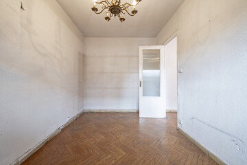 Empty room in an old flat with white wooden doors with glass and slatted floors