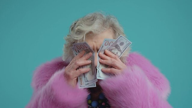 Funny grandmother old woman posing on colored background. Grandma influencer with fashionable clothes on stage, Concept about seniority and third age