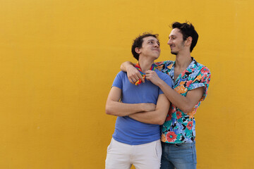 Happy young couple embraces. Two men enjoy outside.