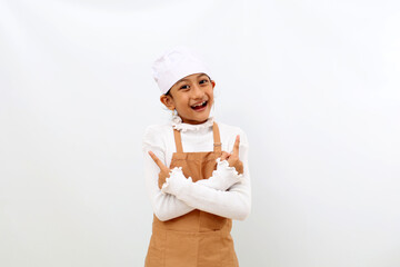 Cheerful little girl in chef uniform pointing both sides. Isolated on white background