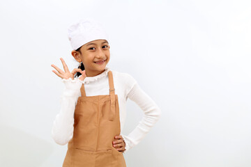 Cheerful little girl in chef uniform showing okay hand gesture. Isolated on white background - Powered by Adobe