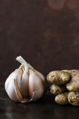 Garlic bulb and onions on a dark table, raw garlic and onions , Allium sativum and Allium cepa