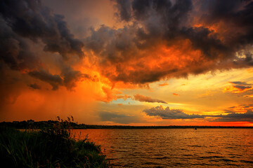 Fototapeta na wymiar Fantastically beautiful sunset on the shore of the lake
