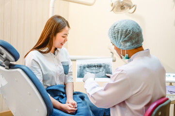 The dentist is looking at the patient's dental x-ray results for an effective treatment and...