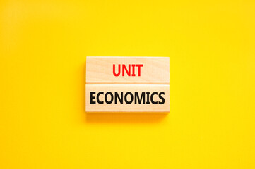 Unit economics symbol. Concept words Unit economics on wooden blocks. Beautiful yellow table yellow background. Business and unit economics concept. Copy space.