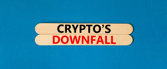 Crypto downfall symbol. Concept words Cryptos downfall on wooden stick. Beautiful blue table blue background. Business and crypto downfall concept. Copy space.