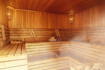 Fototapeta na wymiar Interior of Finnish sauna, classic wooden sauna with hot steam. Russian bathroom. Relax in hot sauna with steam. Wooden interior baths, wooden benches and loungers accessories for sauna, spa complex