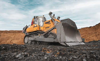 Yellow excavator in career moves overburden. Bulldozer working in an open pit. Bulldozer combs the...