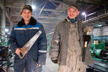 Two bad unskilled workers in bad dirty tattered uniform with bad tools. Concept of unskilled...