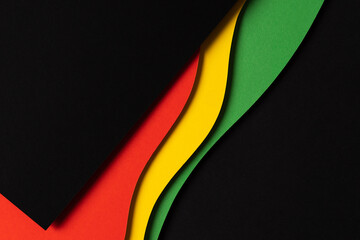 Black History Month color background. Abstract black, red, yellow, green color background with geometrical wavy lines and shapes. Top view