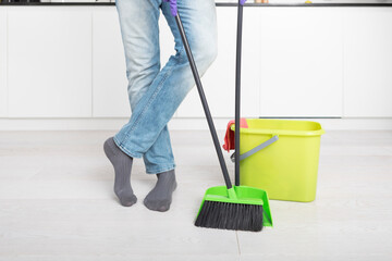 Close up of cleaning tools and male foots at home	
