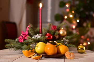 christmas still life with candle, apples and tangerines on the table