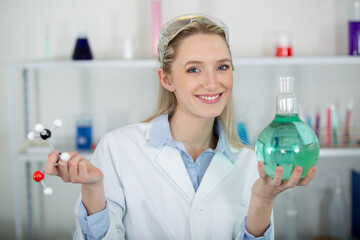 female scientist holding flask and molecule