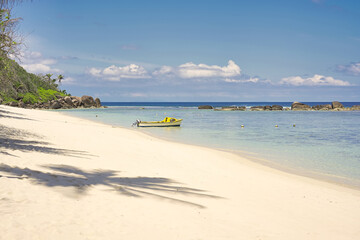 Mahe Seychelles, Anse forbans beach calm seas and white sand. blue sky and low tideland docking boat 