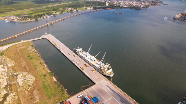 image of white ship with cranes moored at port terminal