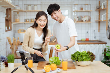 Happy cheerful Asian man and woman talking about cooking and food nutrition in a beautiful...